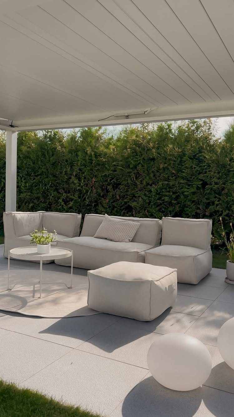 Modular light grey outdoor sofa sections with an ottoman and coffee table on a patio.