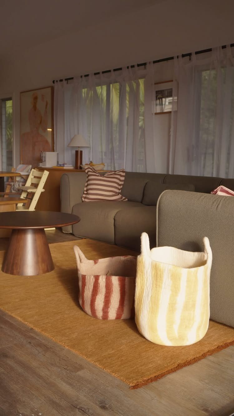 5 Creative Hidden Toy Storage Solutions to Reclaim Your Space 1 Two striped fabric storage baskets sitting on a brown rug in a living room.