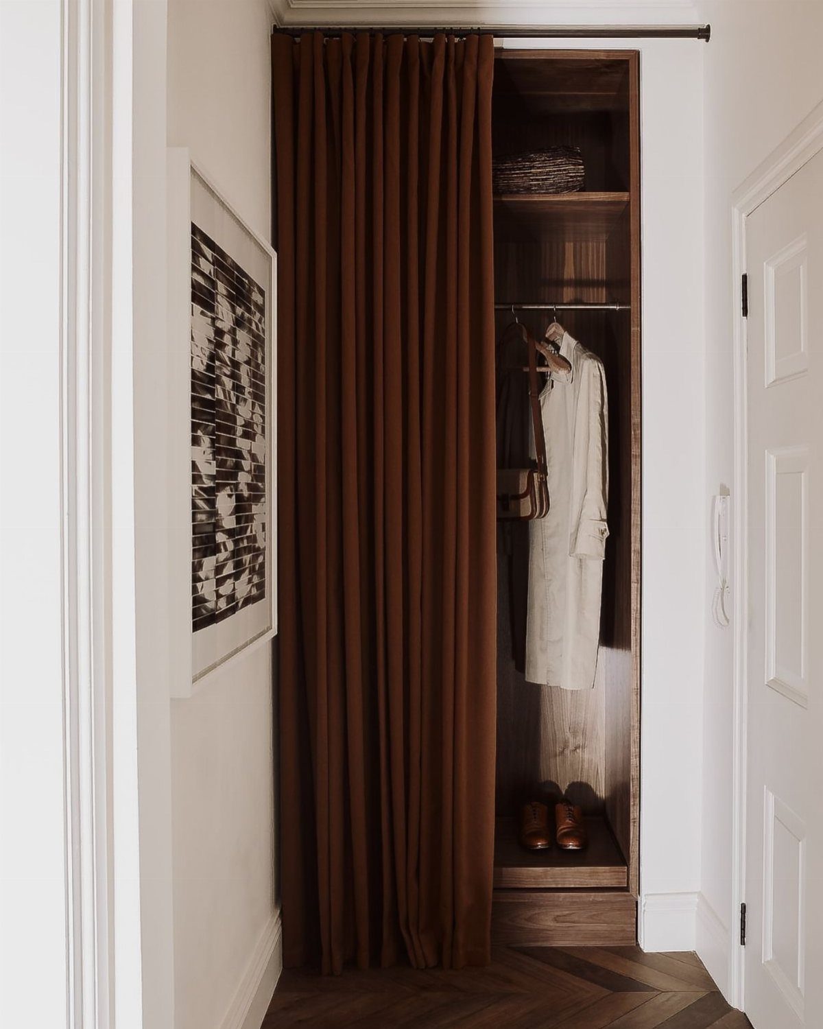 11 Curtain Closet Ideas for Style and Space 11 Brown curtain covering an open wooden closet containing a white garment and brown shoes.