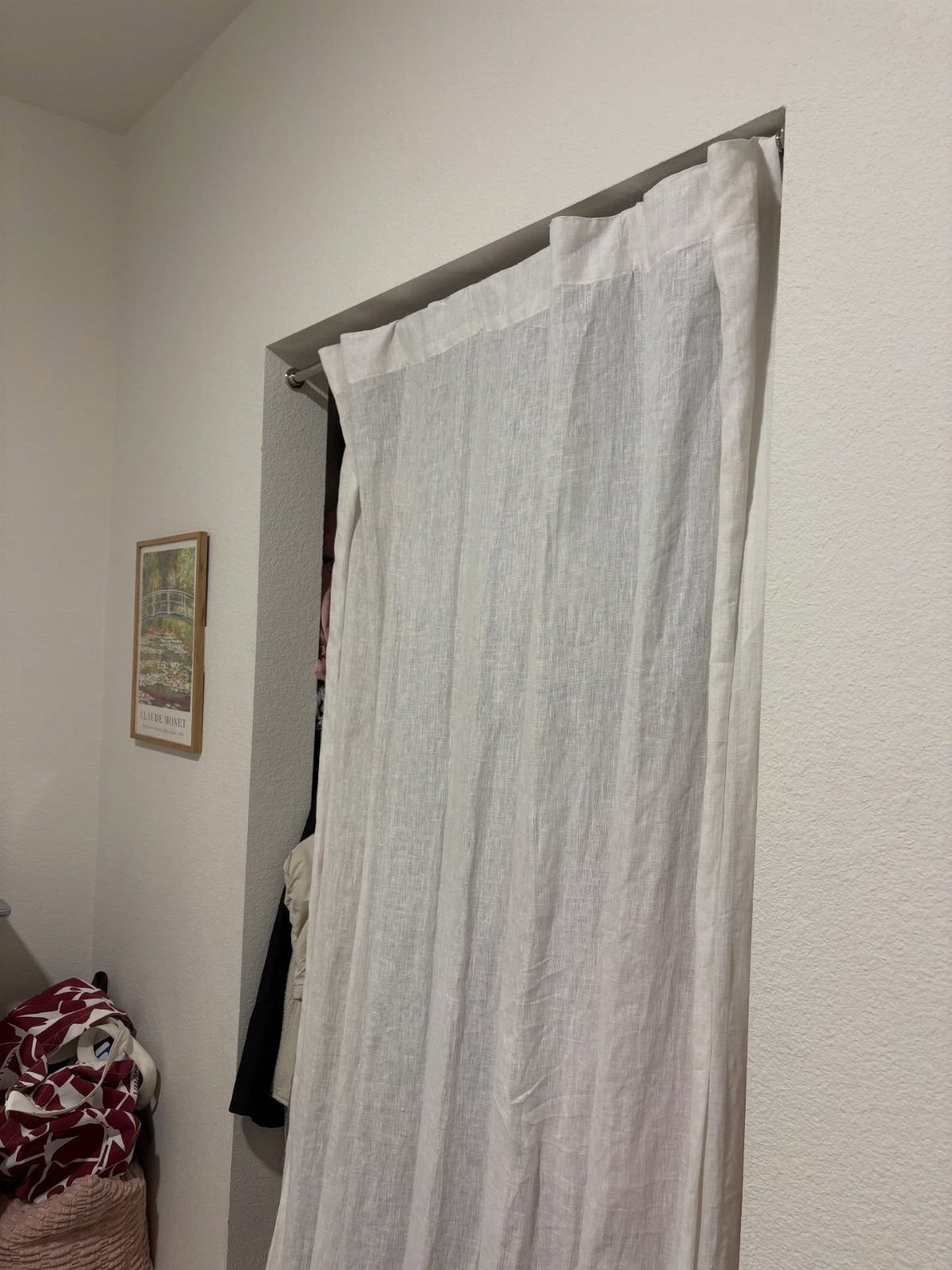 11 Curtain Closet Ideas for Style and Space 3 White sheer fabric curtains hanging from a tension rod in a closet doorway.
