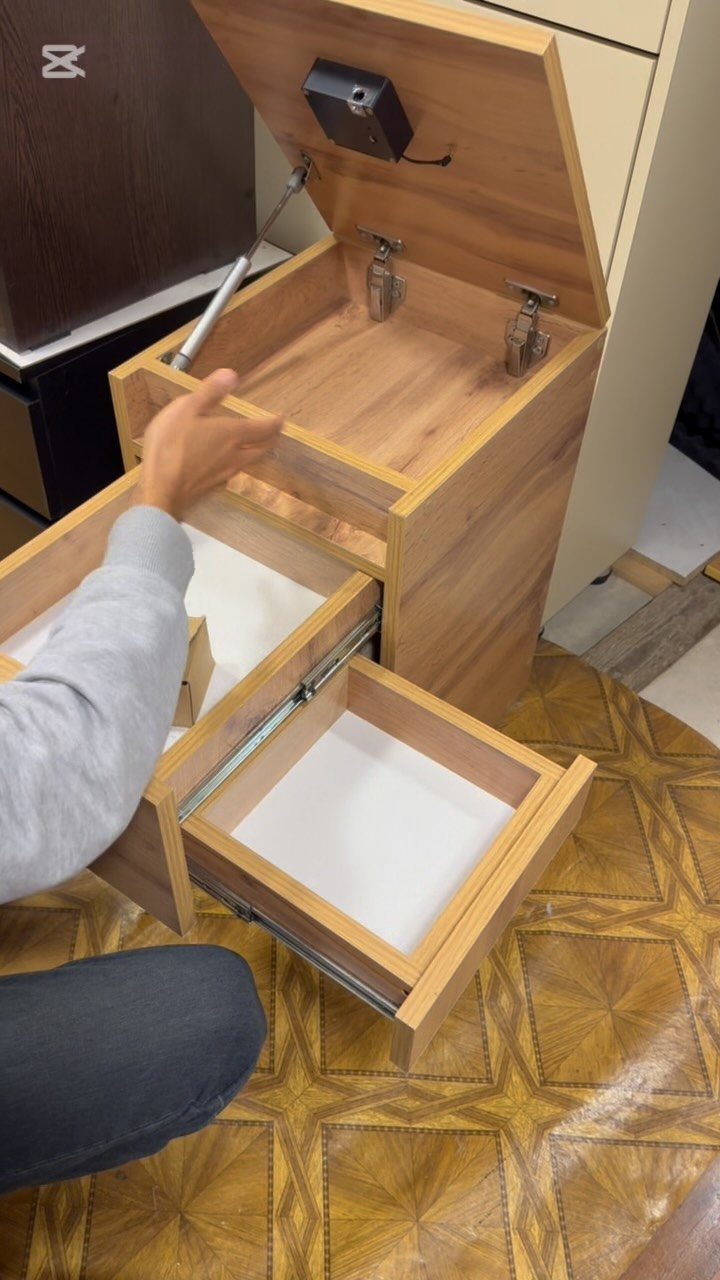 Wooden cabinet with multiple drawers being opened to reveal empty storage compartments.