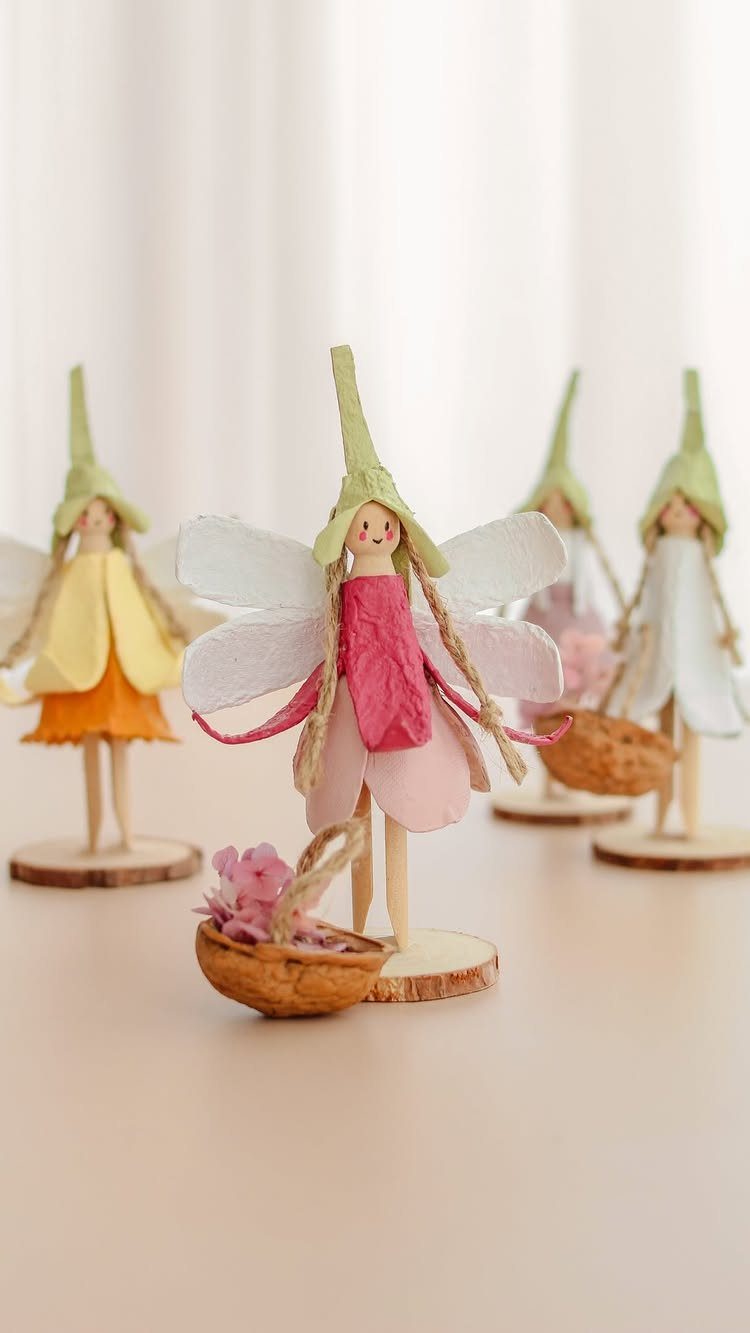 23 Fairy Garden Ideas for Tiny Houses, Teacups and Tree Trunks 17 Handmade paper fairy figurines with colorful dresses and wings standing on wooden bases.