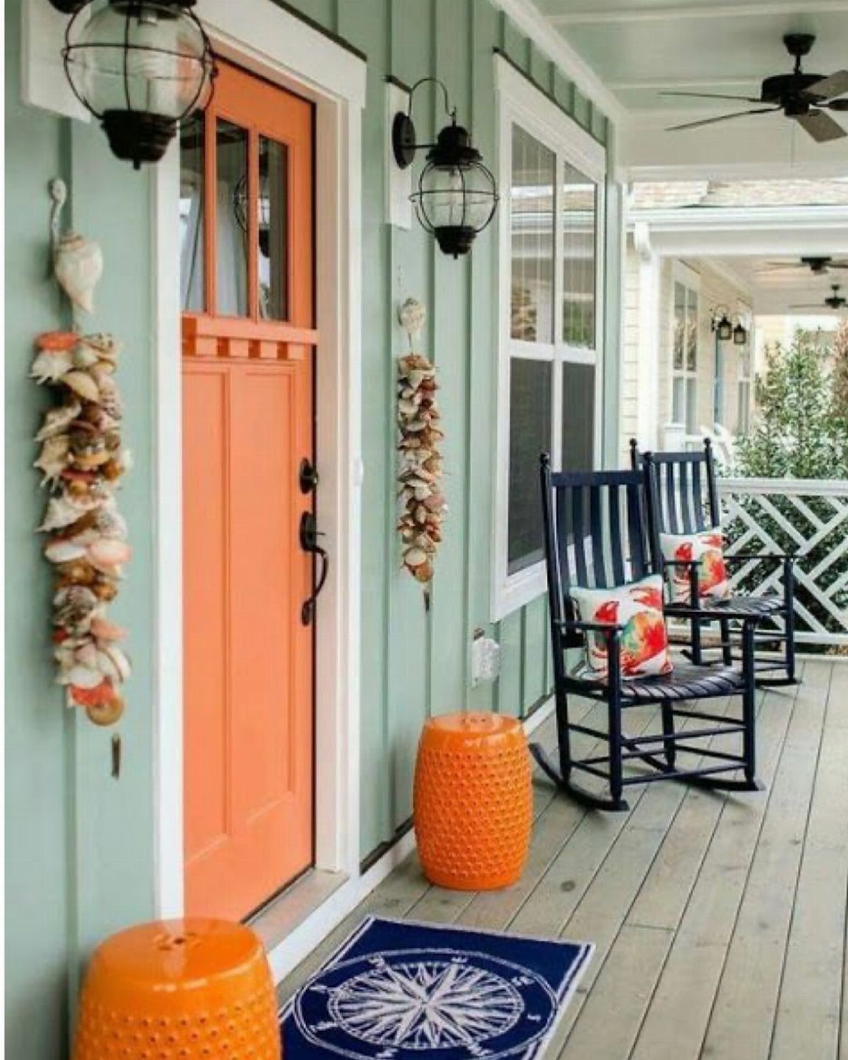 14 Front Porch Decorating Ideas for Every Season 8 Orange front door and garden stools paired with navy blue rocking chairs on a green porch.