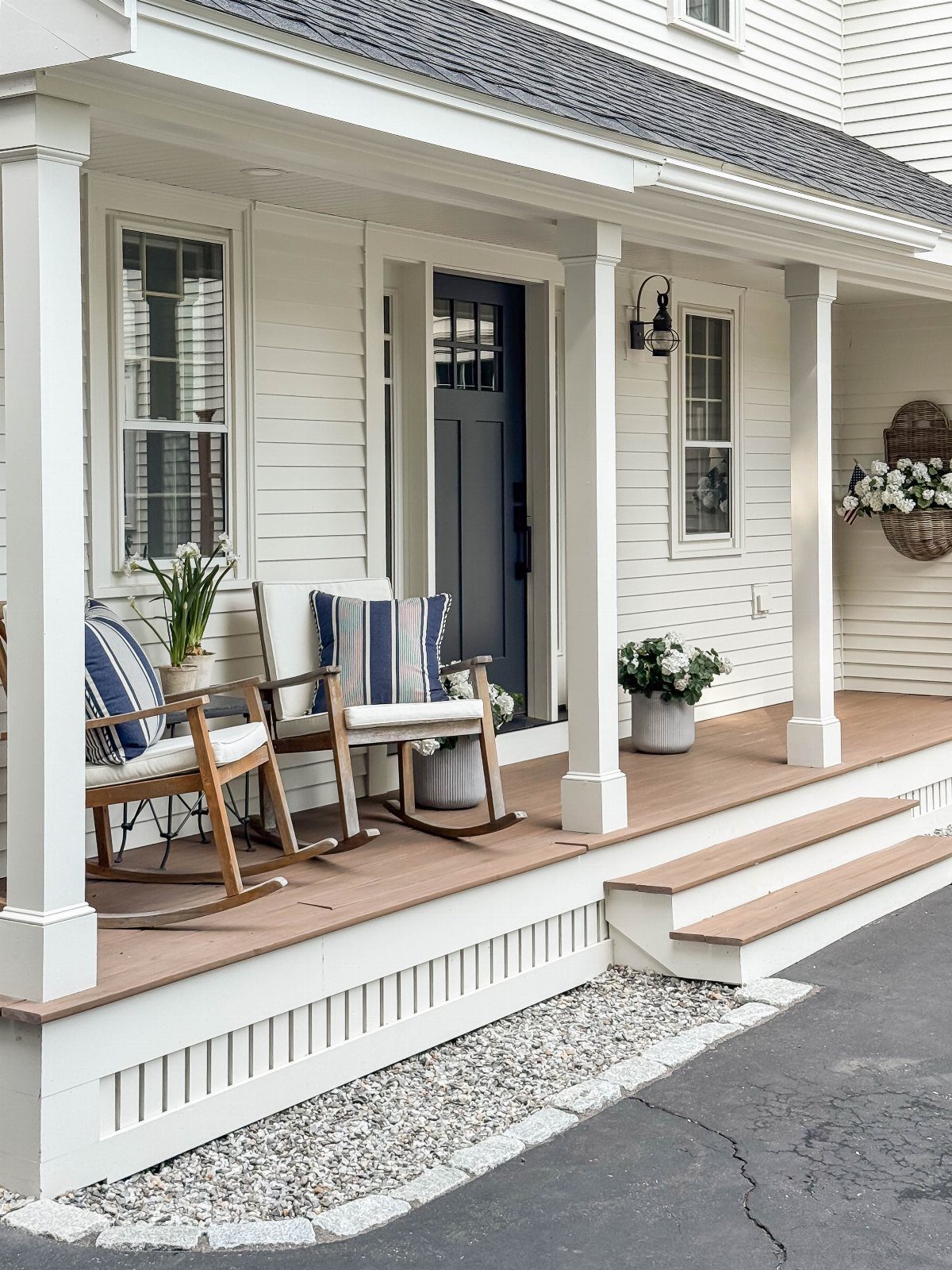 14 Front Porch Decorating Ideas for Every Season 4 Two wooden rocking chairs with striped pillows sit on a white and wood front porch.
