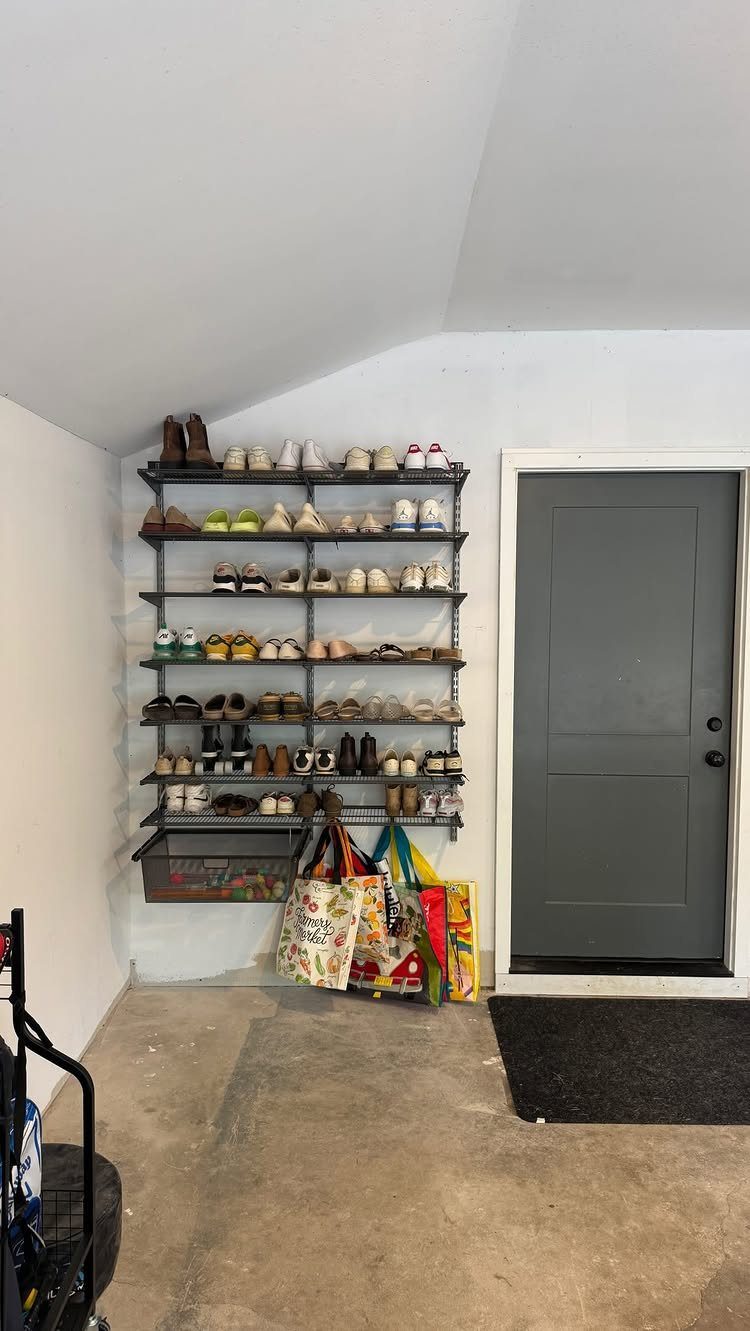 9 Garage Storage Shoes For Any Budget, Wall to Floor 7 Metal wall shelves filled with various pairs of shoes in a garage setting.
