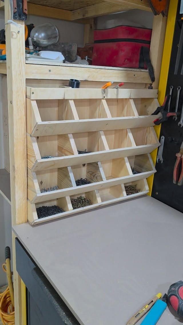 Garage Storage Using Pallets: 5 Projects for Vertical Racks and Tool Cubbies 3 Wooden shelving unit with small compartments filled with various metal screws and bolts on a workbench.