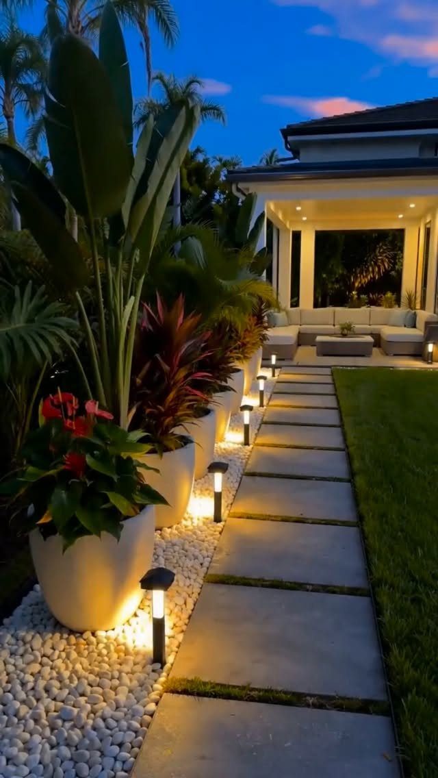 10 Garden Pathways Ideas for Gravel, Brick, Wood and Stone 10 Rectangular concrete pavers create a lit pathway through a tropical garden with white gravel and potted plants.