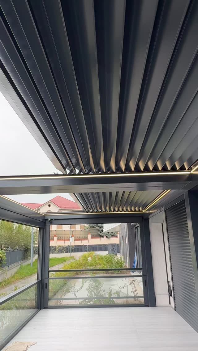9 Modern Deck with Pergola Ideas for Living, Shade & Dining 8 Dark grey aluminum pergola with adjustable louvered roof slats over a modern deck.