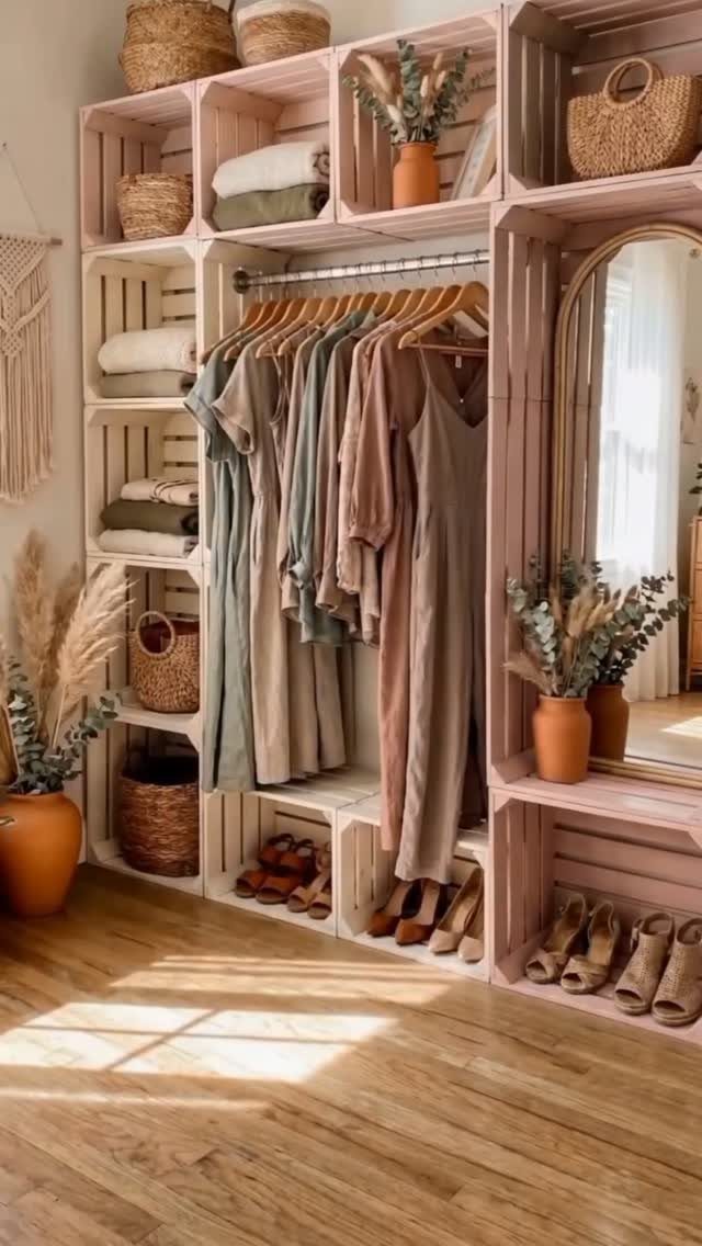 11 No Closet Room Ideas for Clothing Racks, Under-Bed Storage and More 7 Pink wooden crate shelving unit holding hanging clothes, folded textiles, and woven storage baskets.