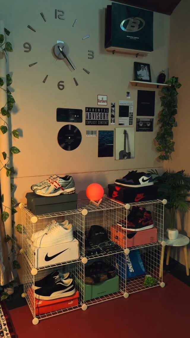 White wire grid cubbies filled with sneakers and colorful shoe boxes against a decorated wall.