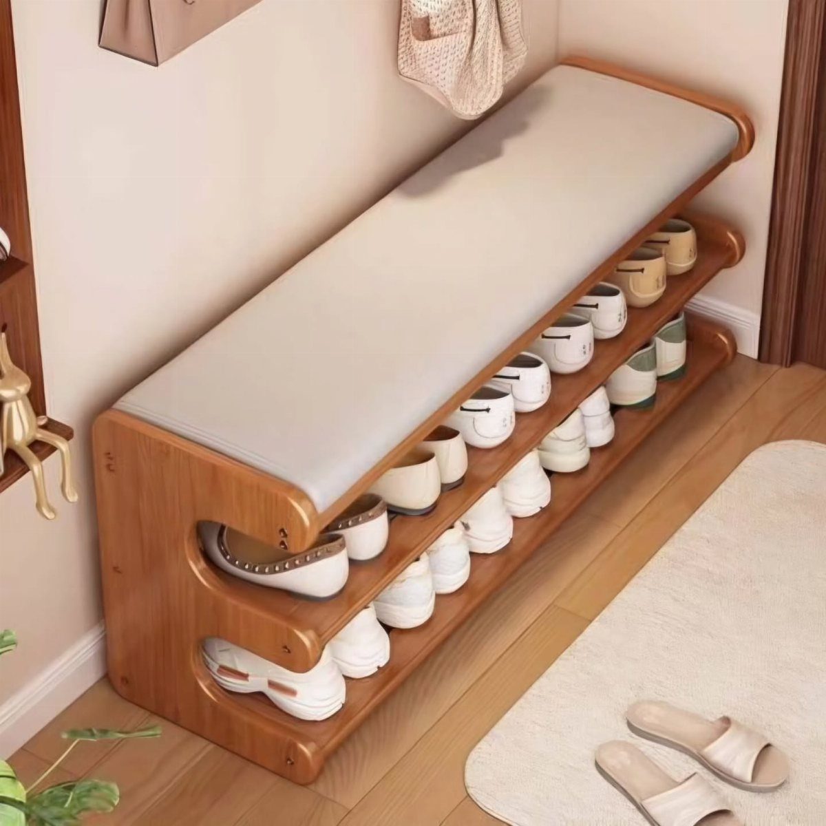 Wooden shoe storage bench with a white cushioned seat and multiple rows of shoes underneath.